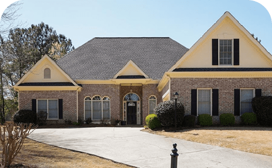 A large brick house with black shutters and a white door.